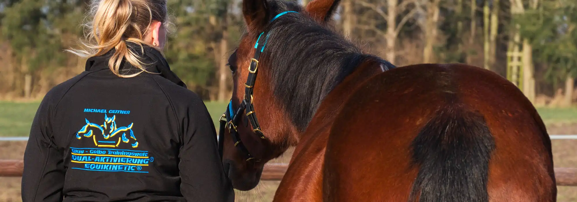 Jenny Winter mit einem brauen Pferd auf der Koppel